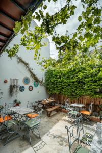 a patio with tables and chairs and a fence at Bouti Ayvalık in Ayvalık