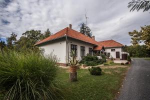 uma pequena casa branca com um telhado vermelho em Zsitfapusztai Vadászház em Vizvár
