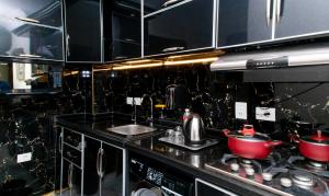 Porto Said Tourist Resort Luxury Hotel Apartment في بورسعيد: مطبخ مع حوض وموقد مع قدور ومقالي