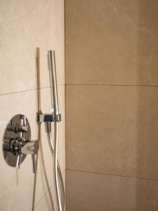 un cabezal de ducha en la pared del baño en Dimora NiLu' en Margherita di Savoia