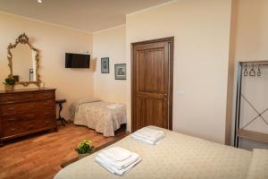 1 dormitorio con 2 camas, tocador y espejo en Agriturismo Villa Val D'Olivi en Capodacqua