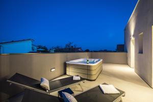 ein Badezimmer mit einer Badewanne auf dem Dach eines Gebäudes in der Unterkunft Villa Aida - 4 bedroom luxury villa with large private pool 4K projector and Jacuzzi in Pula
