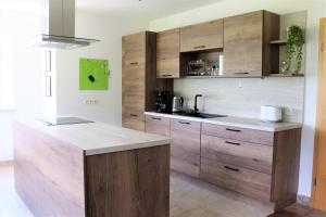 a kitchen with wooden cabinets and a counter top at Ferienwohnung am Einödhof in Uttendorf