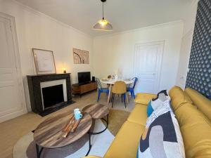 a living room with a couch and a table at Jaurès 2 - T3 - 5p - Tramway - Gare - Centre Ville in Le Mans