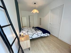 a bedroom with a bed with a black and white comforter at Jaurès 2 - T3 - 5p - Tramway - Gare - Centre Ville in Le Mans