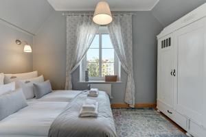 een slaapkamer met 2 bedden en een raam bij Downtown Apartments Old Town Długa Vintage in Gdańsk