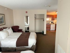a hotel room with a bed and a kitchen at River Hills Hotel- Mankato in Mankato