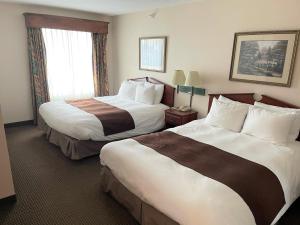 a hotel room with two beds and a window at River Hills Hotel- Mankato in Mankato