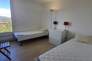 1 dormitorio con 2 camas y ventana en Spacious T4 with sea and Esterel views, en Saint-Raphaël