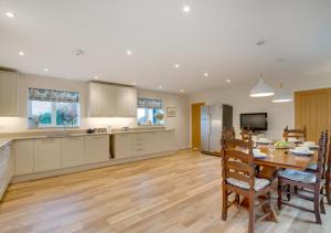 a large kitchen and dining room with a table and chairs at Valley View in Colyton