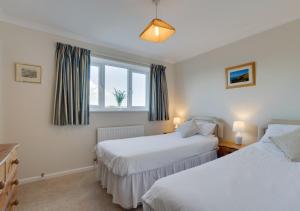 a bedroom with two beds and a window at Valley View in Colyton