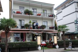 Menschen stehen auf dem Balkon eines Gebäudes in der Unterkunft Hotel Rialto in Riva del Garda