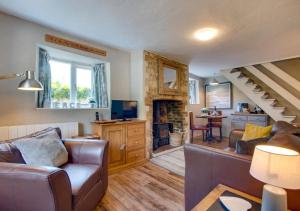 a living room with a couch and a fireplace at Otters Corner in Branscombe