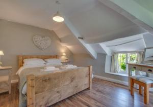 a bedroom with a large bed and a window at Otters Corner in Branscombe