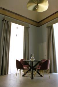 a dining room with a black table and chairs at Palazzo sul Corso-Charming Appartaments in Brindisi