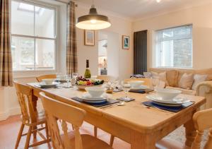 a dining room with a wooden table and chairs at Causeway Cottage in Beer