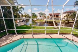 Una vista de una piscina desde una casa. en Bonita Beach River House, en Bonita Springs