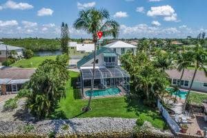 una vista aérea de una casa con piscina y palmeras en Bonita Beach River House, en Bonita Springs