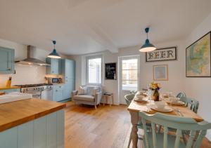 a kitchen and living room with a table and chairs at Victoria Cottage in Beer