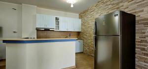 a kitchen with a stainless steel refrigerator and white cabinets at Grillo Superior Apartments in Capo Vaticano