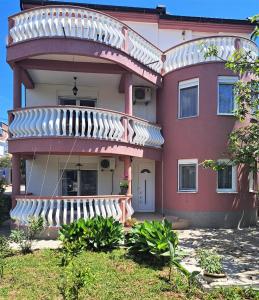 a large red house with a large balcony at Montenegro Smile in Dobra Voda