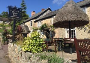 a restaurant with an umbrella and a table and chairs at Florin in Seaton