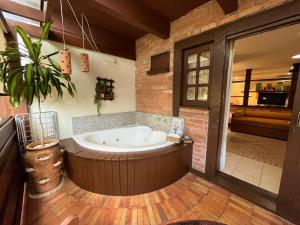 a large bath tub in a room with a plant at Pousada Kaloa Eco Village in Bombinhas