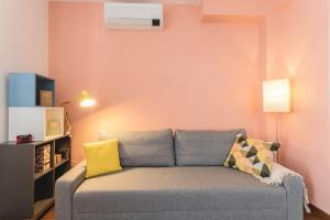 a living room with a gray couch and a yellow pillow at Casa di Design nel cuore di Rimini in Rimini