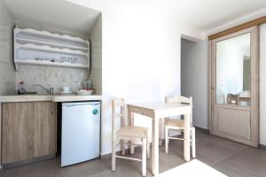 a kitchen with a table and a white refrigerator at Caldera Butterfly Villas in Fira