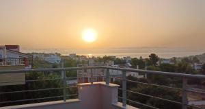 a view of the sunset from the balcony of a building at Petros House Artemis - Near the Airport in Artemida