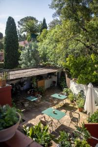 un patio esterno con tavoli, sedie e alberi di unic views begur alojamiento turístico a Begur