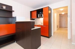uma cozinha com armários laranja e preto e um micro-ondas em Lebic 411 in Marina Portoroz by Locap Group em Portorož