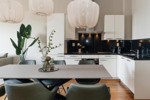 cocina con mesa blanca y sillas en BizStay Harbour IV en Scheveningen