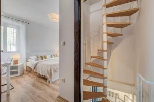 a spiral staircase in a bedroom next to a bed at 3 bedrooms charming stone house in old town in Trogir