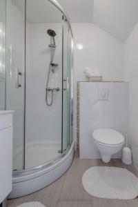 a white bathroom with a shower and a toilet at 3 bedrooms charming stone house in old town in Trogir