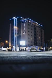 Hotel Vier Jahreszeiten Lübeck في لوبيك: فندق في الليل مع مبنى مضاء