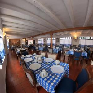 a dining room with blue and white tables and chairs at Hotel Abahunza in Villa de Leyva