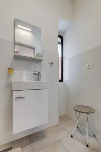 a bathroom with a sink and a stool next to a shower at 3 bedrooms charming stone house in old town in Trogir