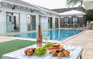 a table with plates of food and a bottle of wine at YalaRent - Liri Resort in Tiberias