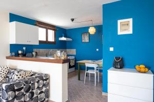 a kitchen and living room with blue walls and a couch at Kalithea Studio 1 in Palekastron