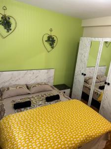 a bedroom with a bed with a yellow comforter at Best holliday Home for family newly renovated in Garges-lès-Gonesse