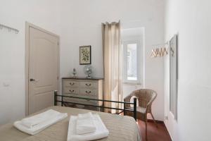 um quarto com uma cama com toalhas brancas em Casa Limoeiro em Albufeira