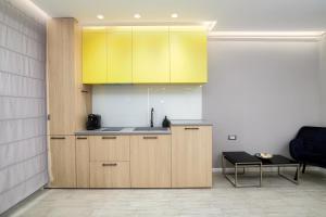 a kitchen with yellow cabinets and a table at Ely's Studio in Mamaia Sat/Năvodari