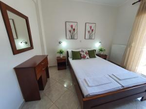 a bedroom with a bed with a dresser and a mirror at Villa Evdokia in Limenaria