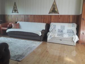 a living room with a couch and a ottoman at Vila Trtović in Nova Varoš