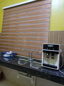 um lavatório de cozinha com um dispensador de sabão por cima em D' Terengganu Homestay em Kuala Terengganu