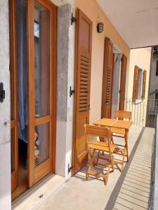 una mesa de madera y un banco en el porche de una casa en Appartamento Borgo Centro, en Borgo