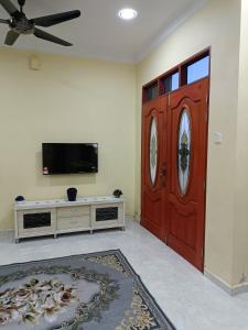 een woonkamer met een grote rode deur en een tv bij D' Terengganu Homestay in Kuala Terengganu