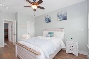 a white bedroom with a bed and a ceiling fan at A Wave From It All - The Ocean Aire, 30 secs from the sand! in Galveston