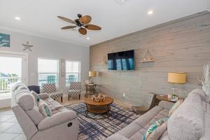 a living room with two couches and a tv at A Wave From It All - The Ocean Aire, 30 secs from the sand! in Galveston